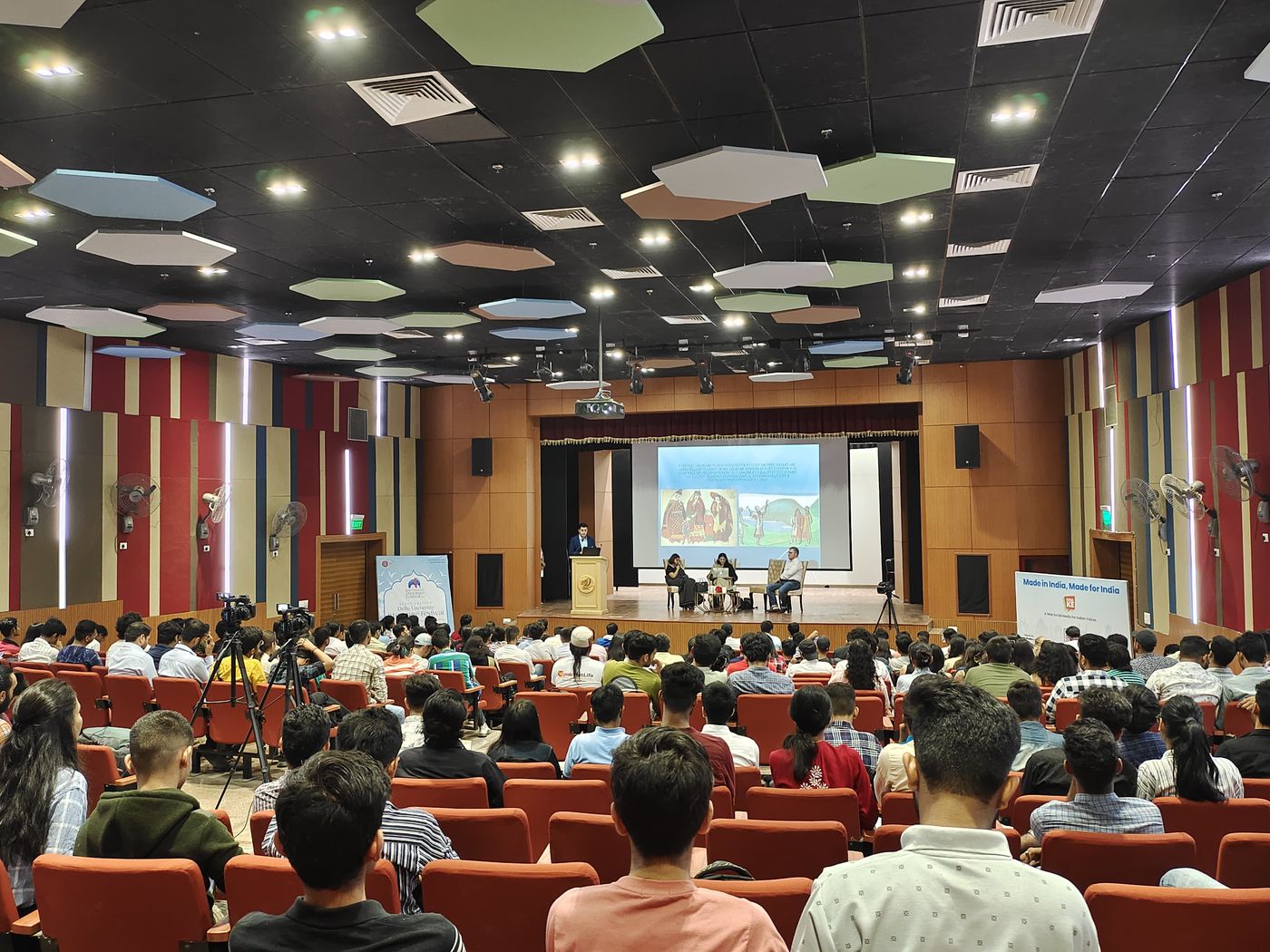 Audience in a packed auditorium during a keynote